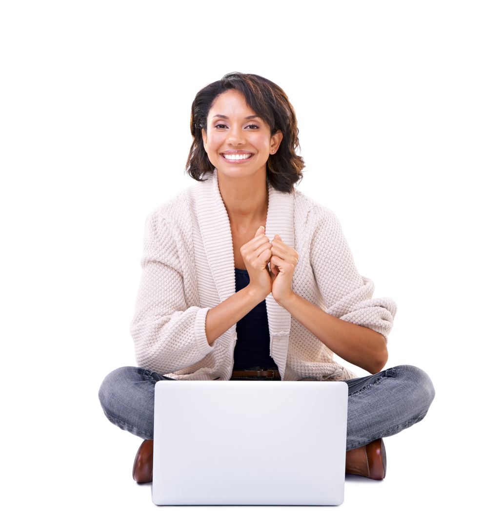 Lovely young woman clasping her hands in excitement while sitting with a laptop