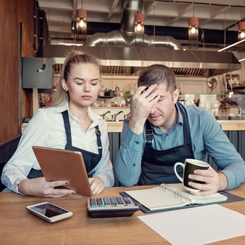 Restaurant Nervous manager checking restaurant finance - Failure in small-business concept. Depressed male and female entrepreneurs overwhelmed by finance problems